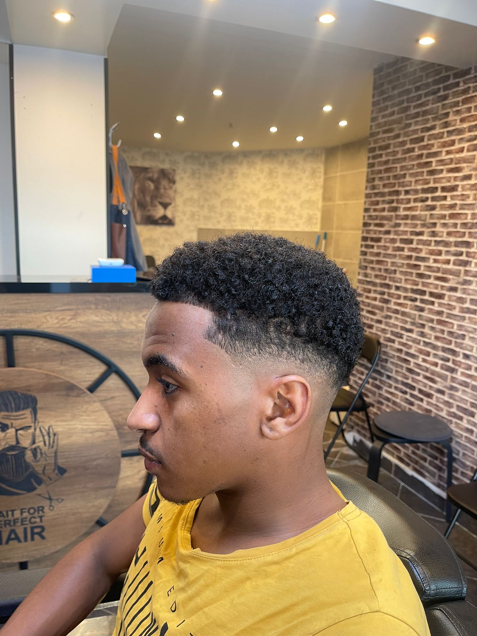 Krullen met een fade, van opzij gezien in de zaak
